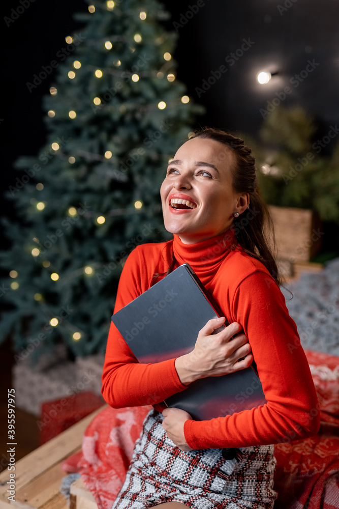 美丽的金发女人在圣诞节前用笔记本电脑和信用卡为家人购物