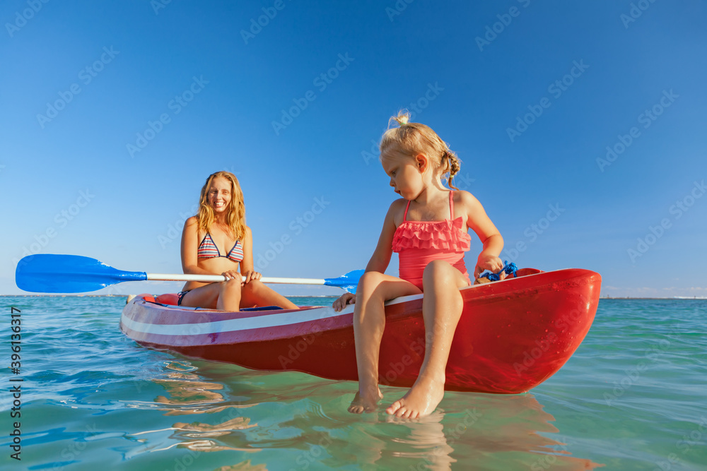 Happy family - young mother, children have fun on boat walk. Woman and child paddling on kayak. Trav