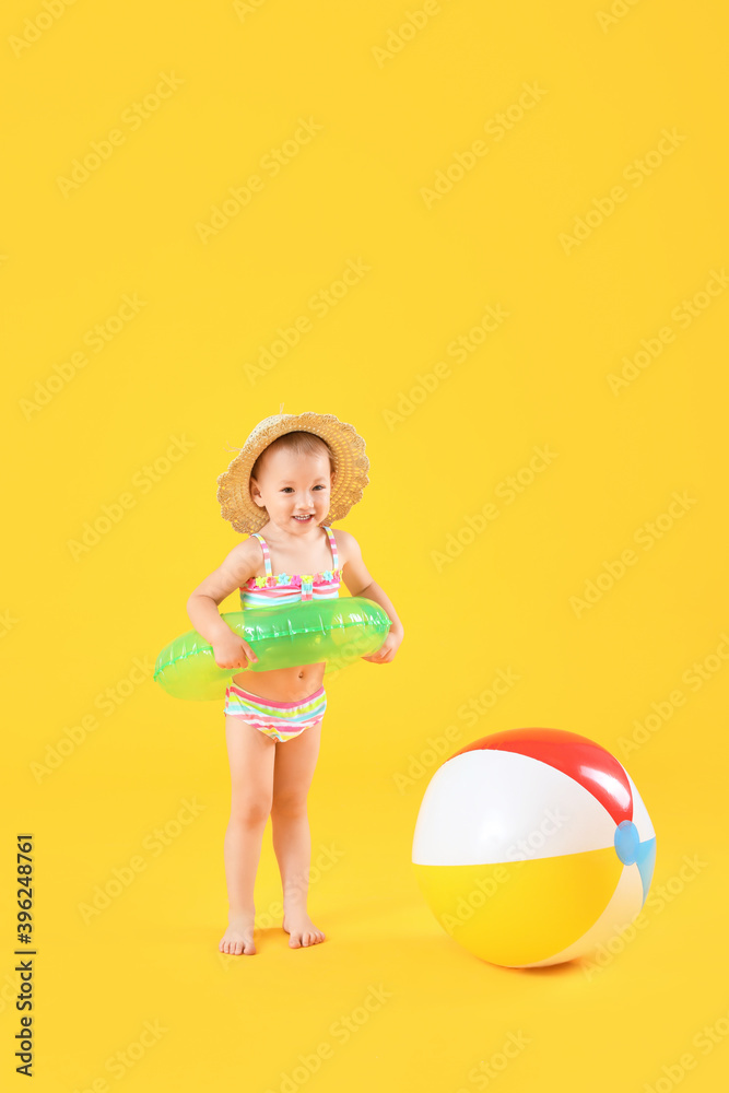 可爱的女婴，背景是充气环和沙滩球