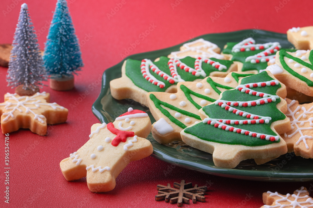 Close up of Christmas sugar cooikes in a plate on red table background.