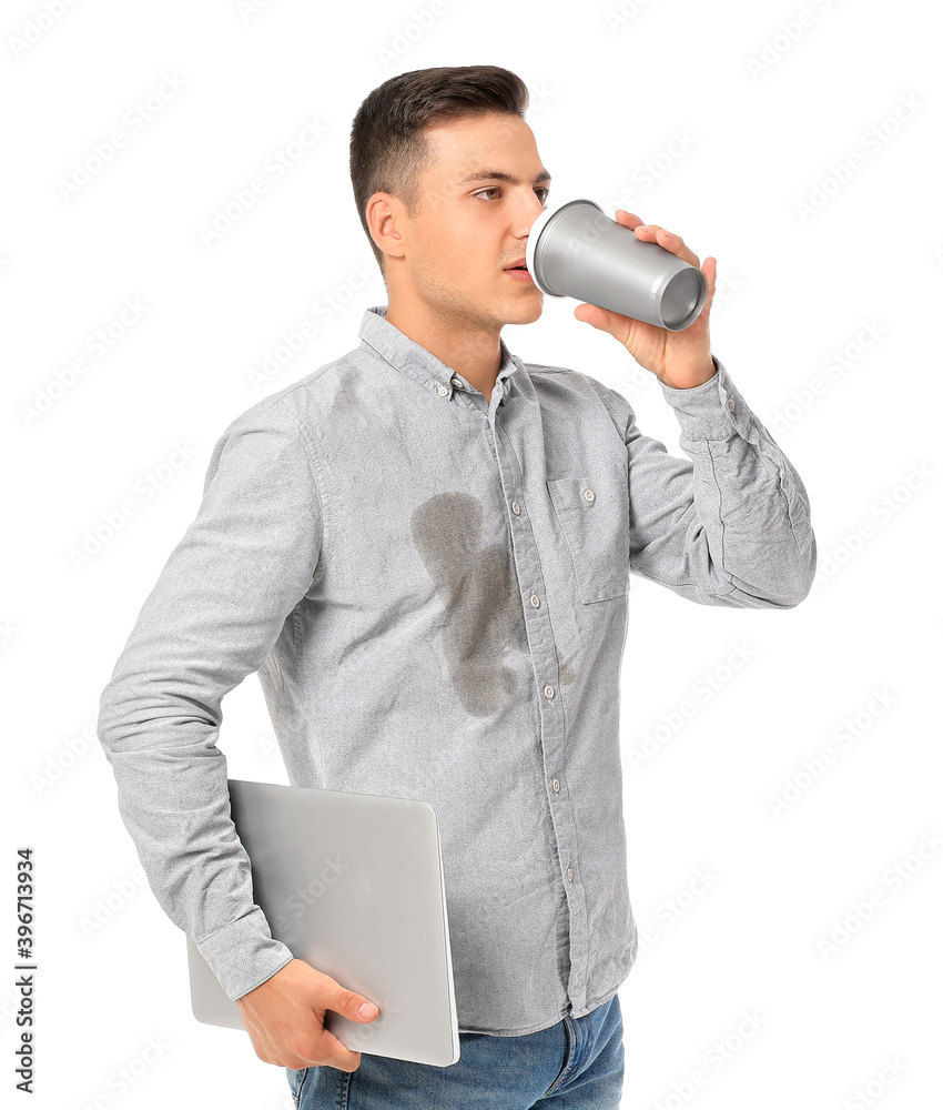 衬衫上有污渍的年轻人喝咖啡，手里拿着白底笔记本电脑