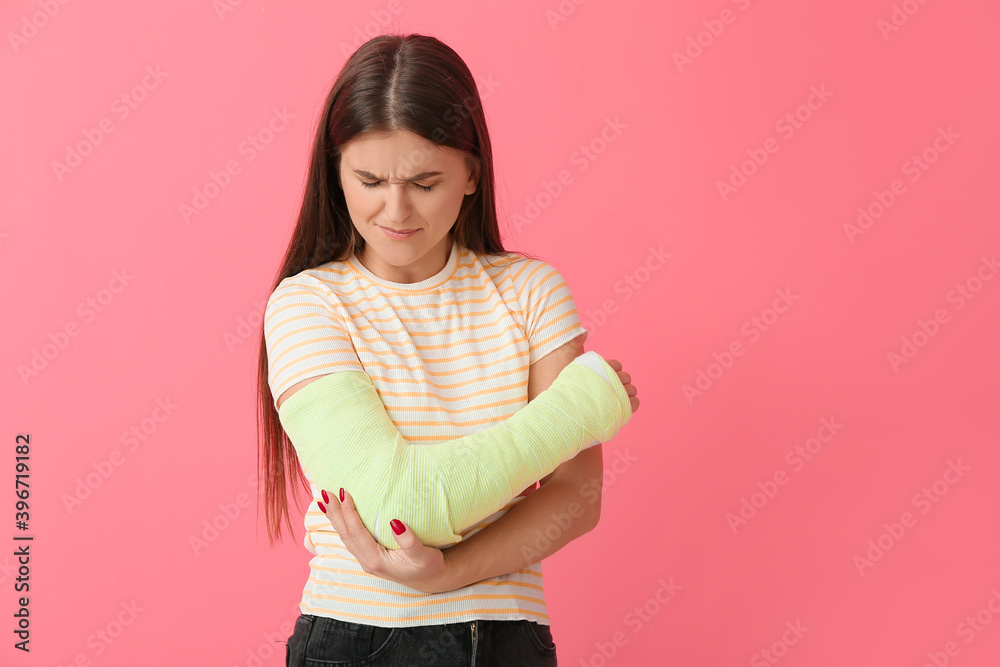 彩色背景下手臂骨折的年轻女子