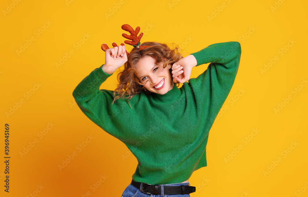 快乐快乐的女人，带着圣诞鹿角跳舞，享受着黄色的生活
