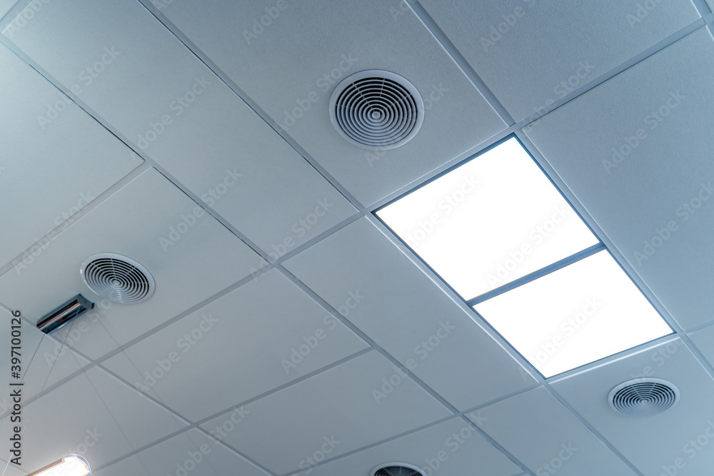 白色办公室天花板，内置荧光灯。天花板上有两个led灯。