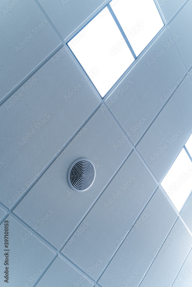现代天花板上的荧光灯。方形瓷砖的发光天花板。