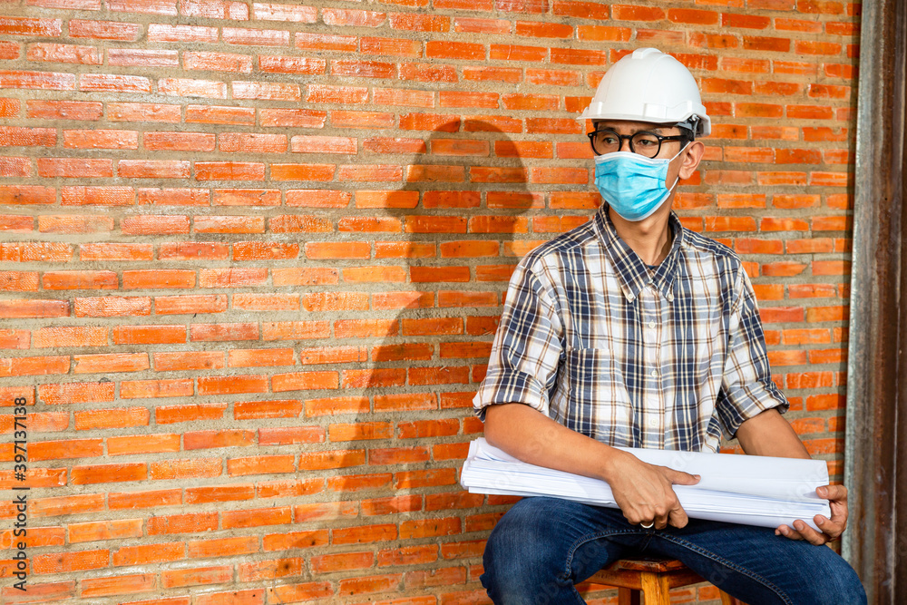 专业工程师或建筑师在施工现场的肖像，并在施工期间佩戴防护口罩