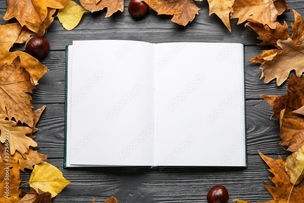 深色木质背景下的秋叶空白书