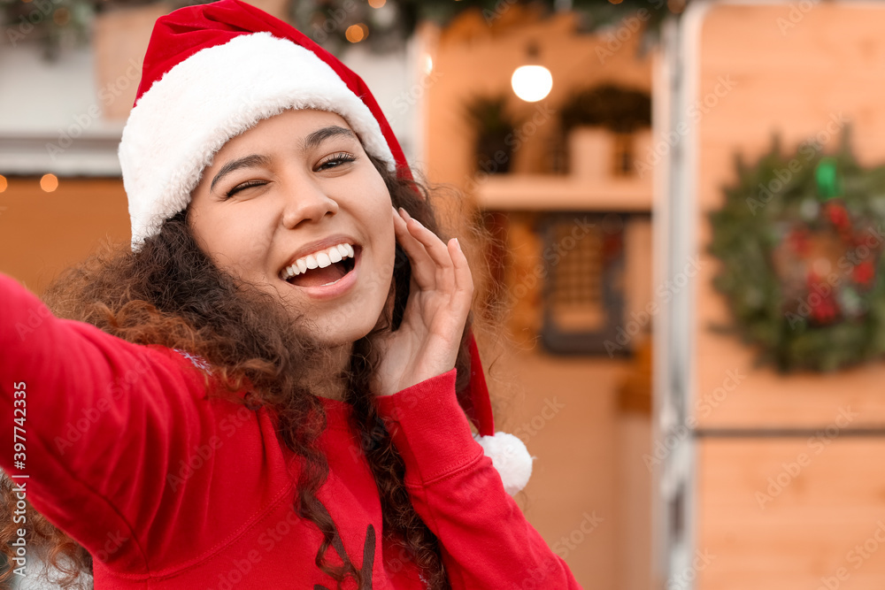 美丽的年轻女子在圣诞节前夕在户外自拍