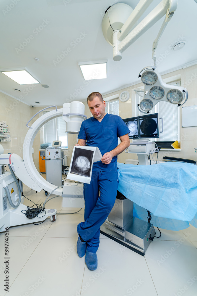 放射科医生或神经外科医生站在高科技现代化手术室里，带着机器人设备。向上