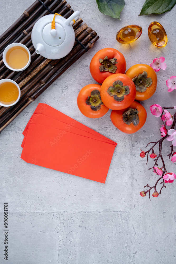 中国农历新年灰色餐桌背景下新鲜甜柿叶顶视图