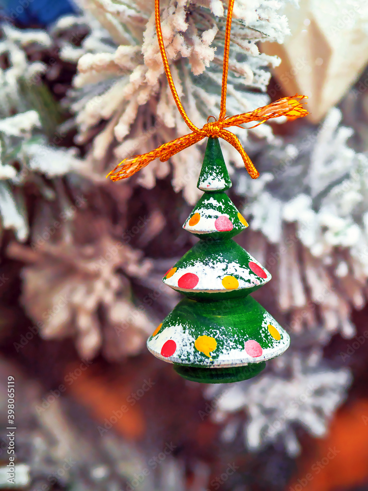 A handmade painted wooden christmas tree on christmas tree background. Closeup.