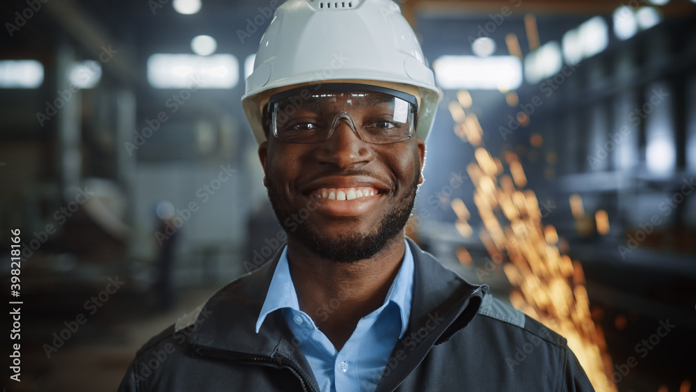 快乐的职业重工工程师/工人穿着制服、戴眼镜、戴着硬帽的肖像照