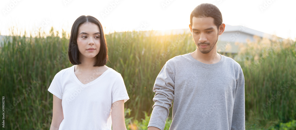 站在草地上的亚洲年轻夫妇的肖像。