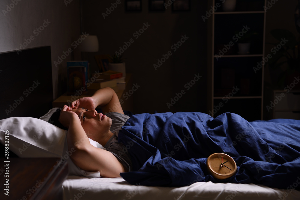 一个情绪低落、失眠的年轻人躺在床上。