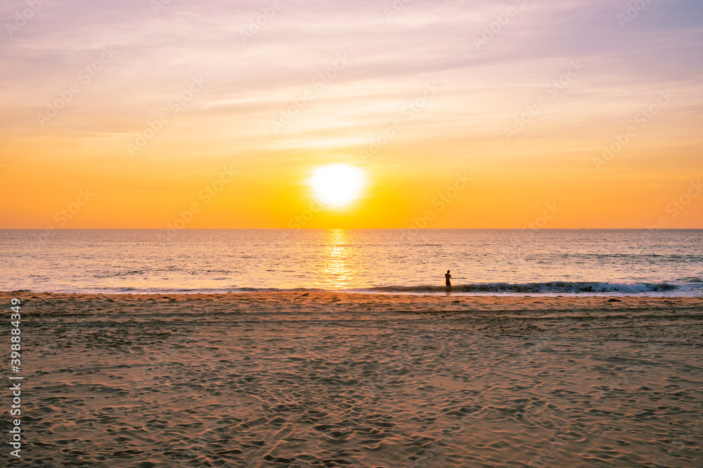 热带海滩上美丽的日落或日出，前景是沙子