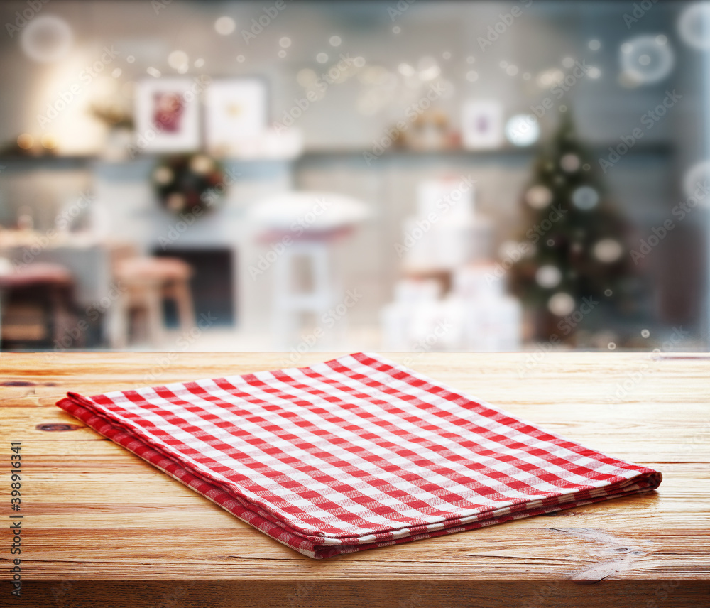 木制桌子和圣诞背景上的红色餐巾。