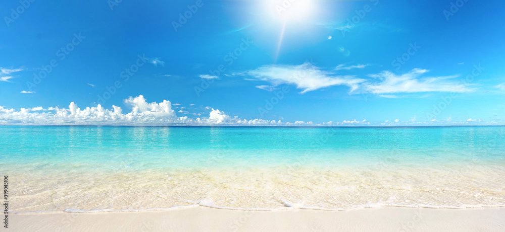 阳光明媚的日子里，美丽的沙滩上有白色的沙子和翻滚平静的绿松石海洋