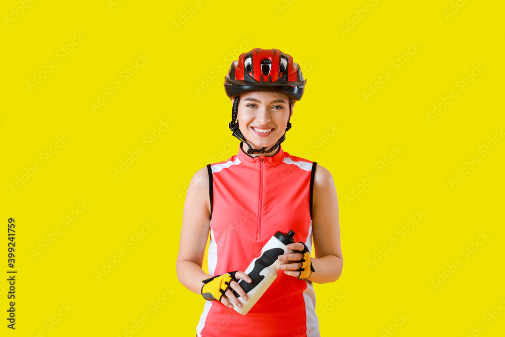 彩色背景上有一瓶水的女自行车手