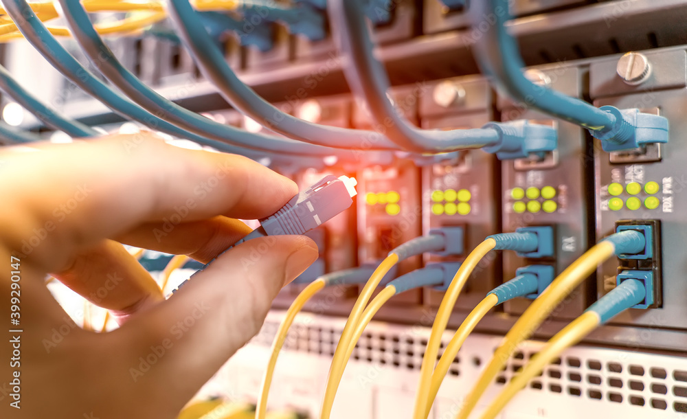 手持连接到数据中心服务器的光纤网络电缆