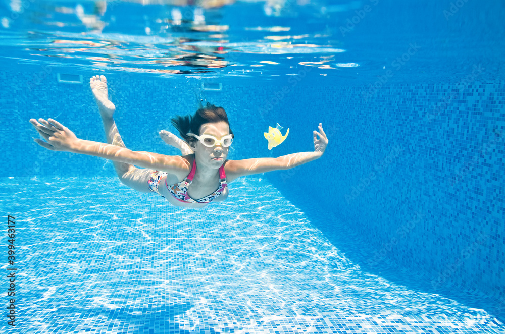 孩子在游泳池的水下游泳，活泼的小女孩在水下潜水，玩得很开心，孩子fitne