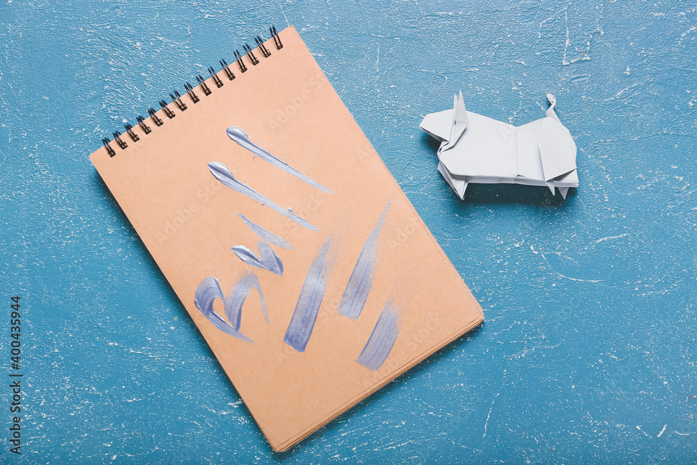 折纸公牛作为2021的象征，彩色背景上的笔记本