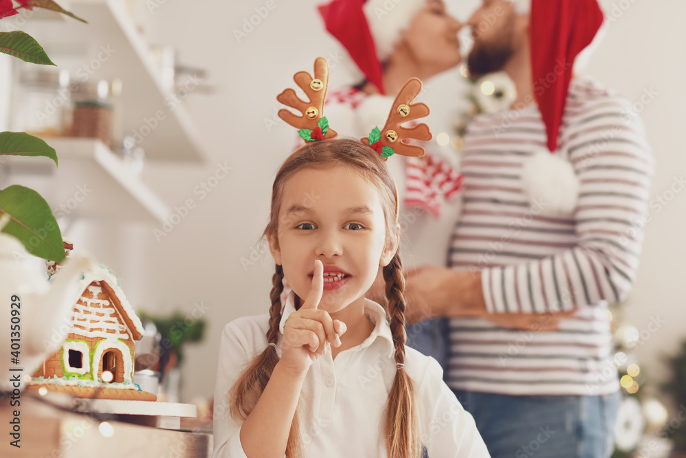 圣诞前夜，小女孩在厨房里做沉默手势