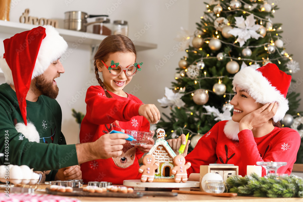 圣诞前夕，幸福的一家人在厨房里做美味的姜饼屋