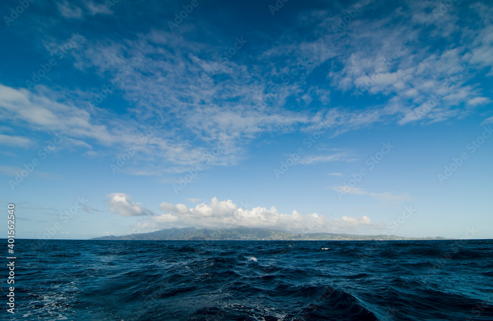 地平线上的加勒比海岛屿。深海波光粼粼，蓝天白云，轮廓分明