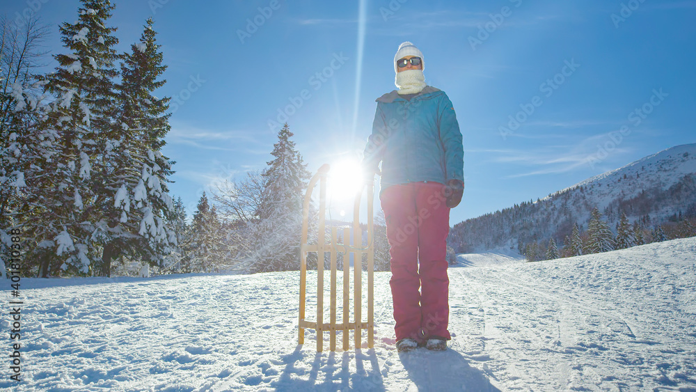 肖像：在克兰季斯卡戈拉，一个有趣的日子里，一位年轻女子站在她的雪橇旁边。