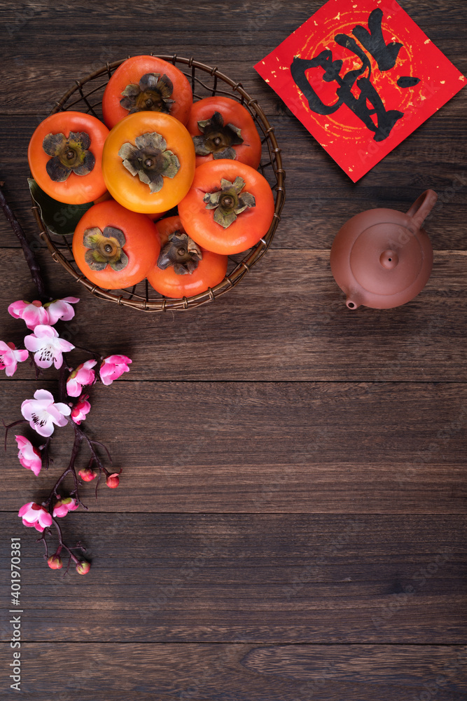 中国农历新年木桌背景上带叶子的新鲜甜柿子俯视图