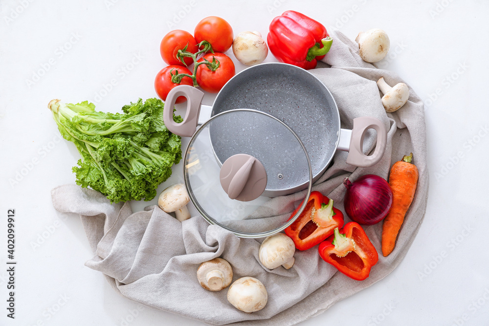 Composition with vegetables, mushrooms and cooking pot on white background