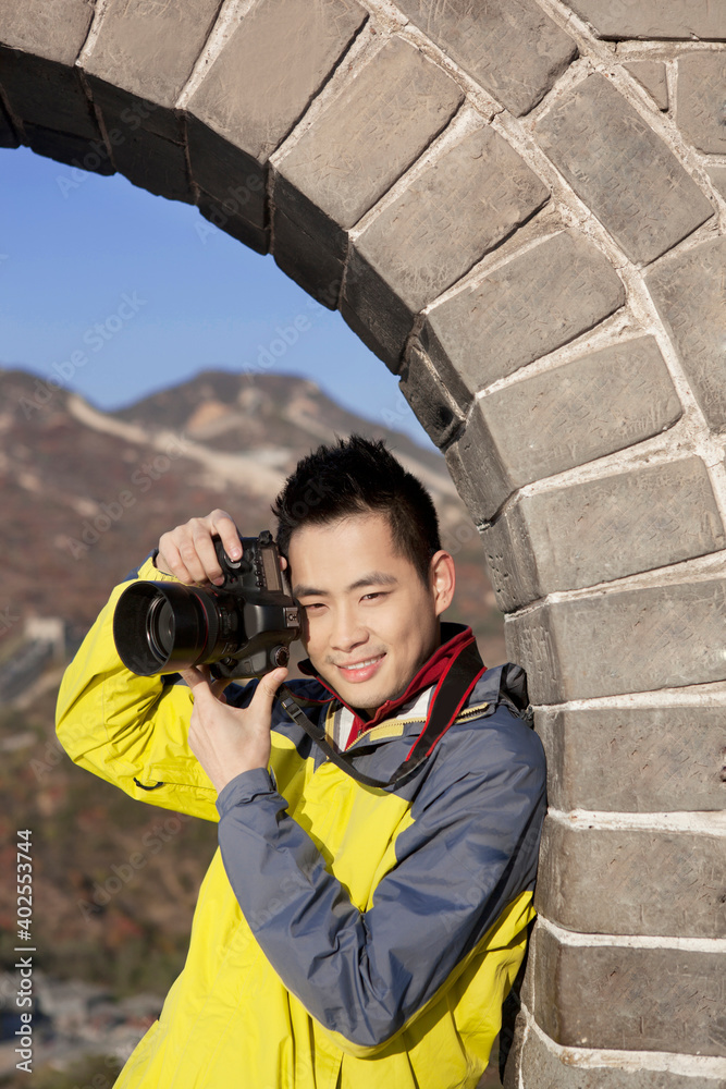 一个年轻人在长城旅游中拍照