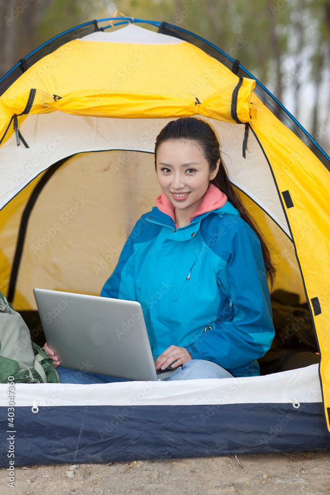 Young women sitting in tents using computers