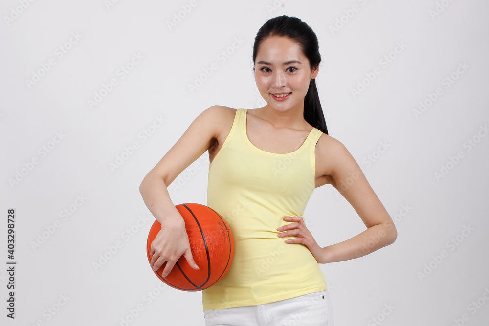 一个快乐的年轻美女在打篮球