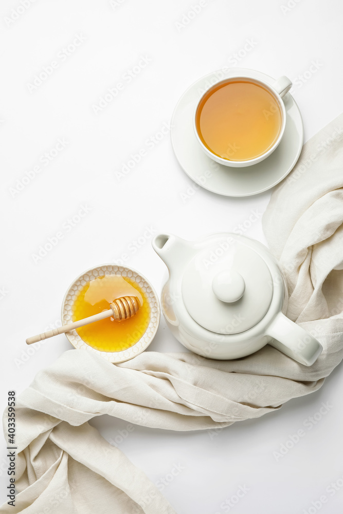 白底茶壶、一杯茶和蜂蜜的构图