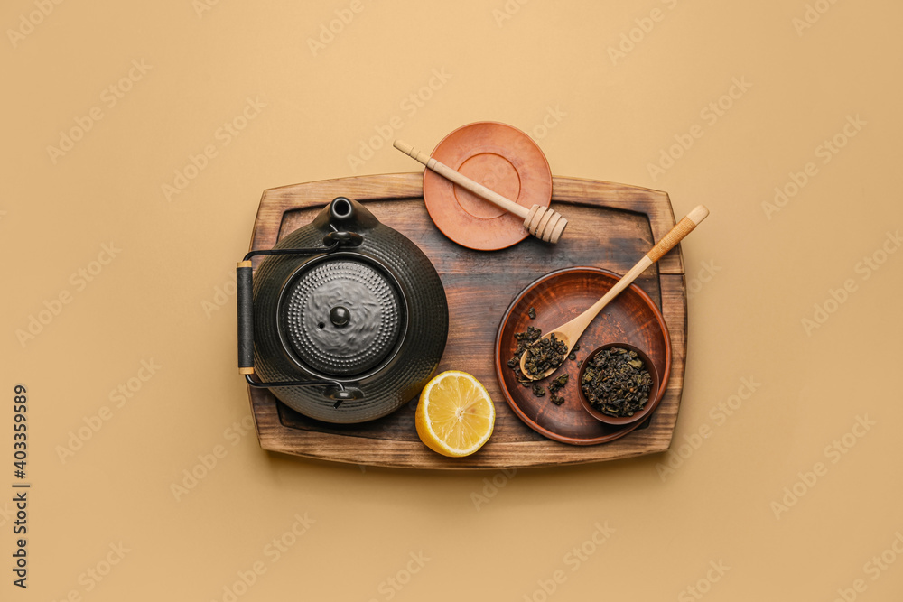 以茶壶、柠檬和干树叶为背景的构图