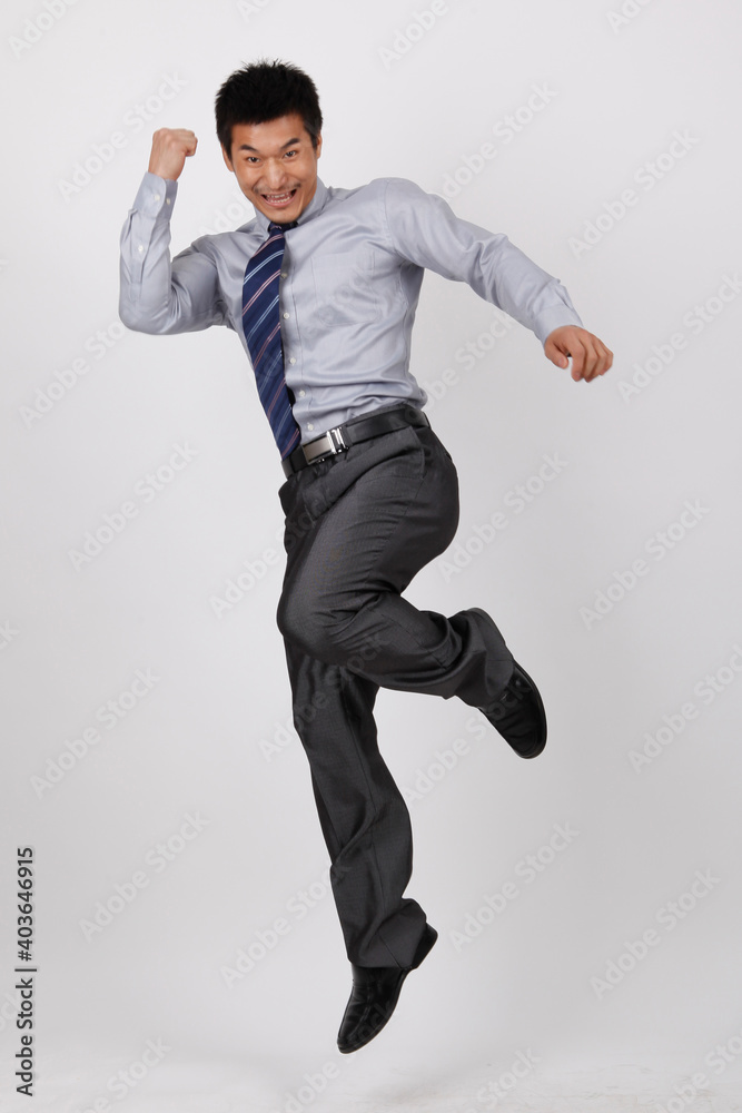 A business man jumping up in a shirt 
