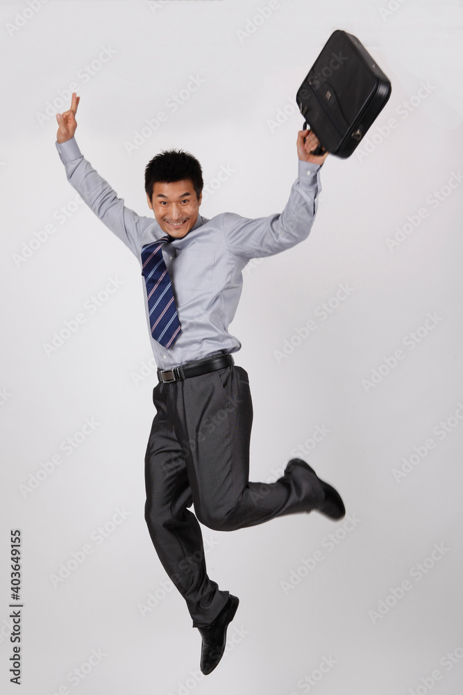 A young business man jumping with a briefcase