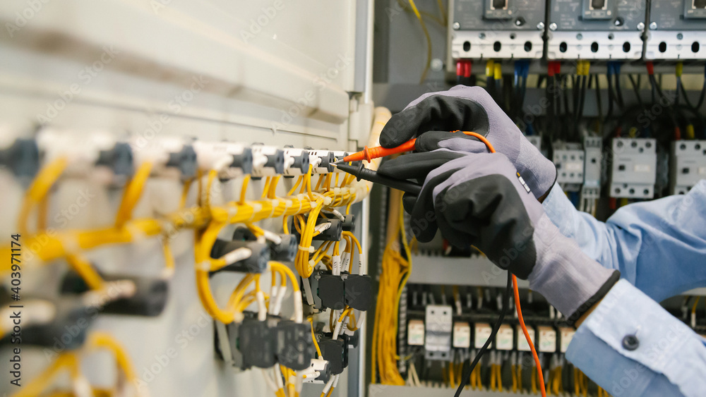电气工程师测试保护继电器上的电气装置和接线，并对其进行测量
