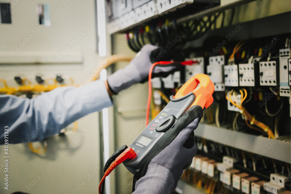 电气工程师测试保护继电器上的电气装置和接线，测量其w