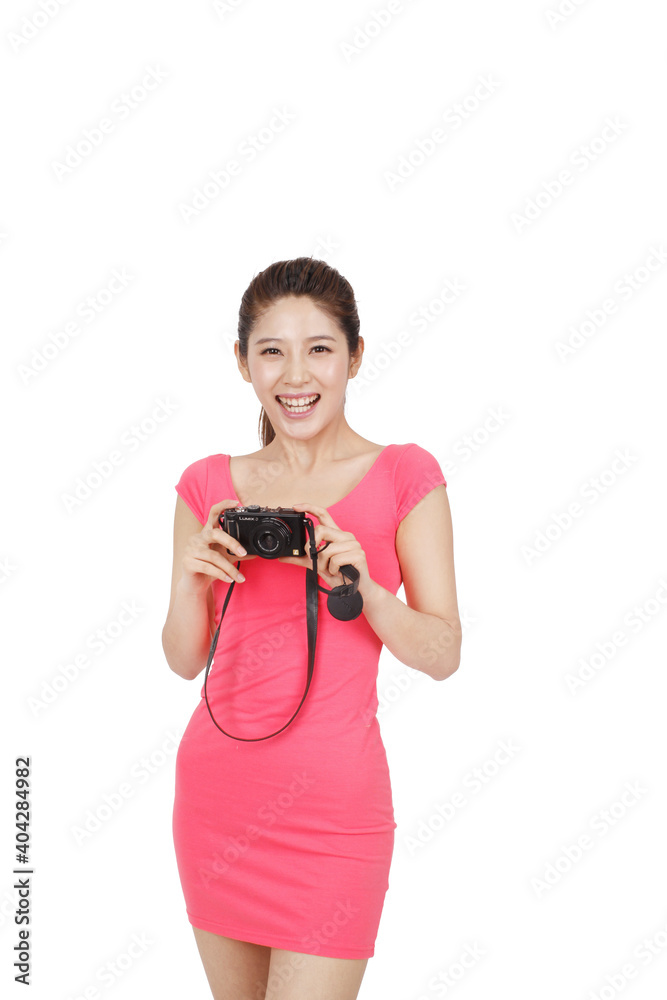 身穿粉色连衣裙的年轻女子拿着相机