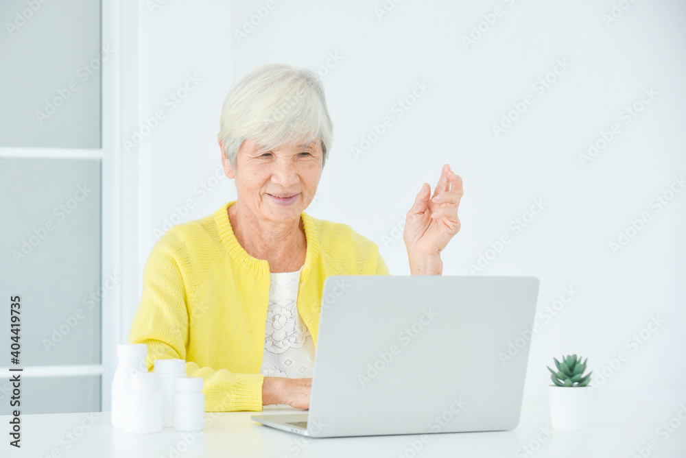 坐在笔记本电脑前与医生视频通话的老年女性。远程医疗公司