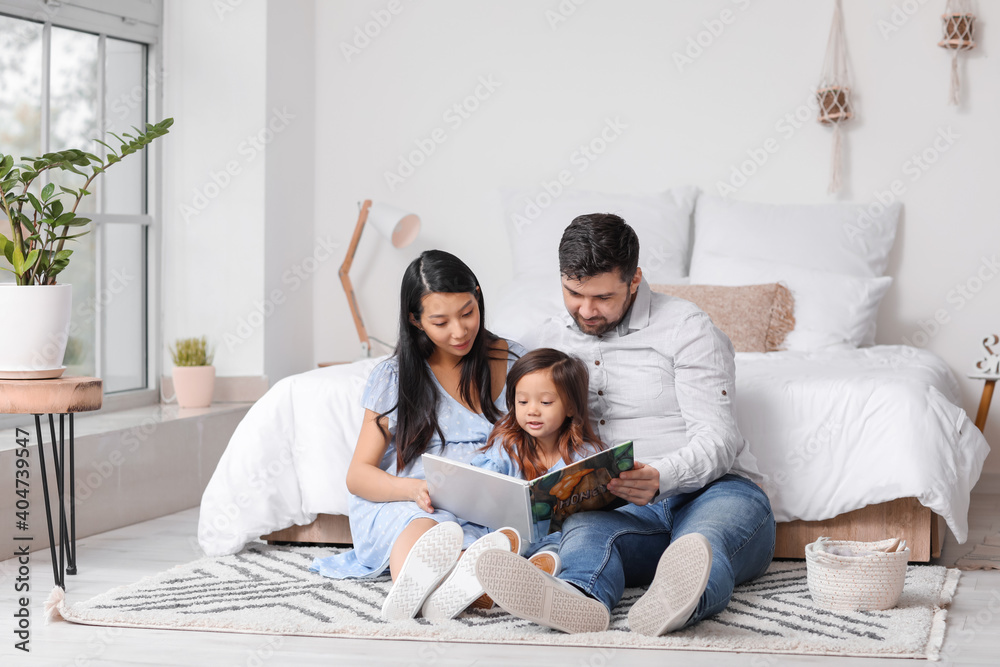 亚洲孕妇和家人在家看书