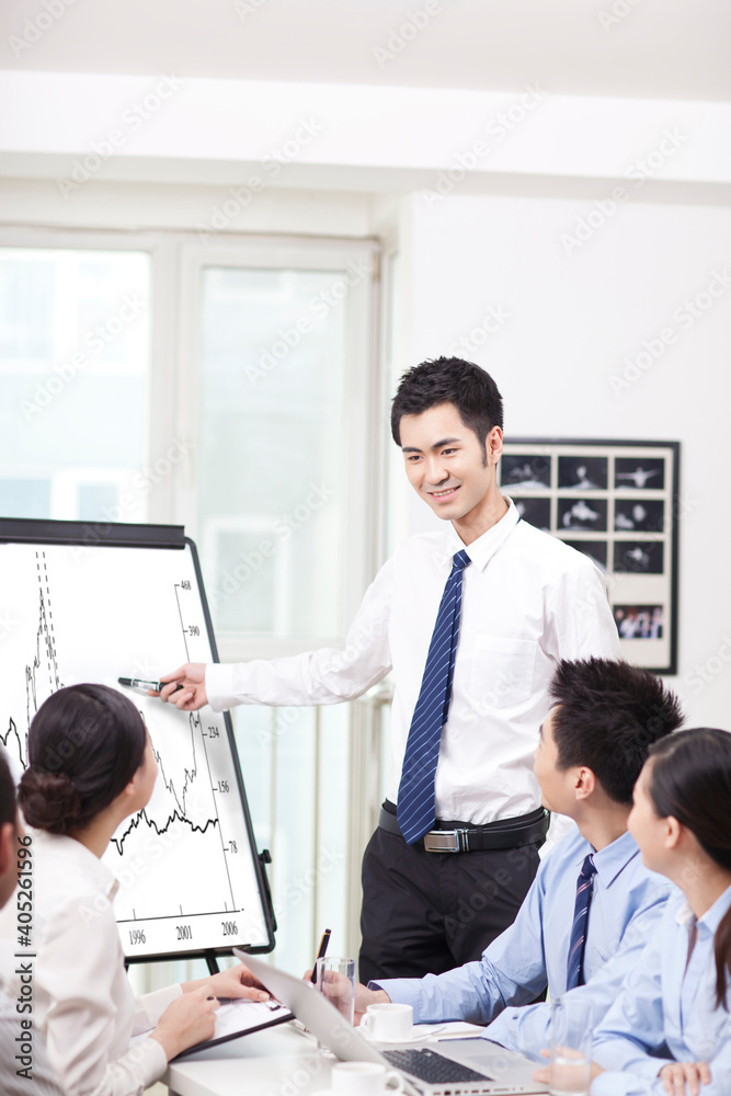 商人在会议室演讲时指着图表