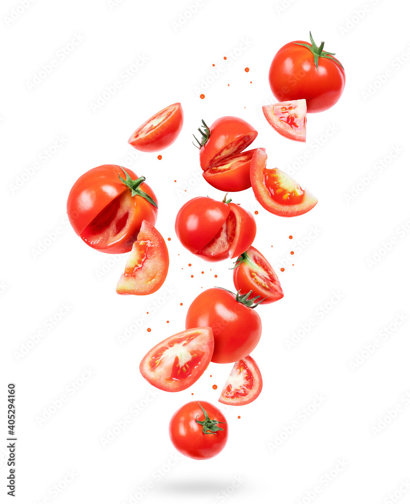 Chopped fresh tomatoes in a chaotic manner in the air on a white background