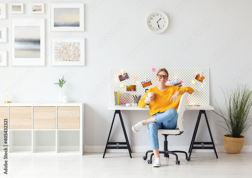 快乐的女人坐在家里的办公室里喝咖啡