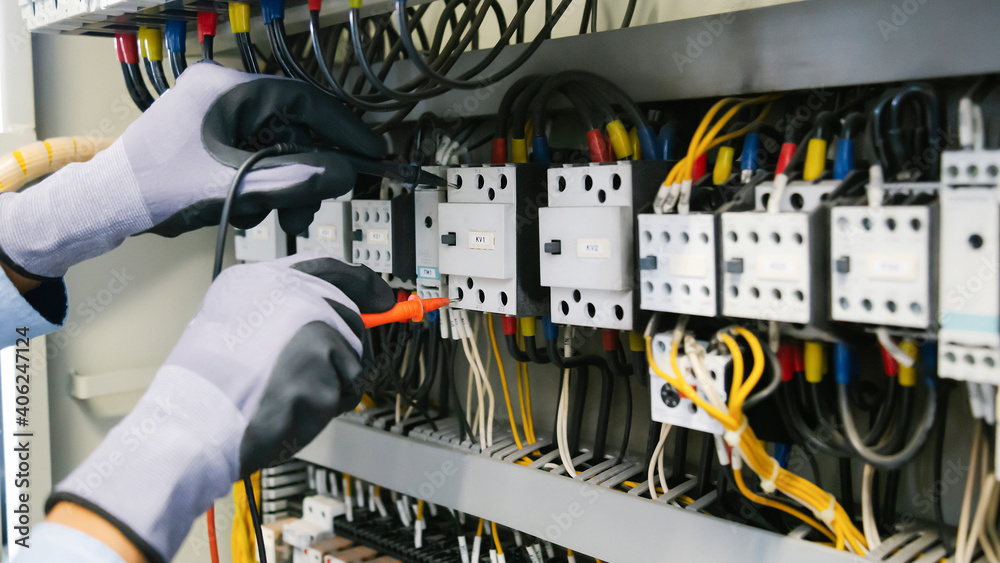 电气工程师测试保护继电器上的电气装置和接线，测量它们w
