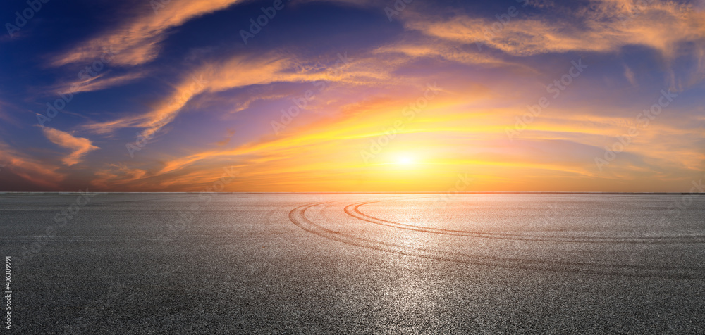 日落时的沥青赛道道路和天空云朵。道路地面背景。