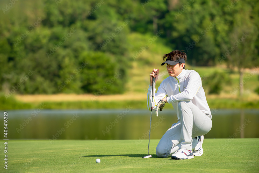 亚洲男子高尔夫球手坐在球道上瞄准高尔夫球场上的高尔夫球