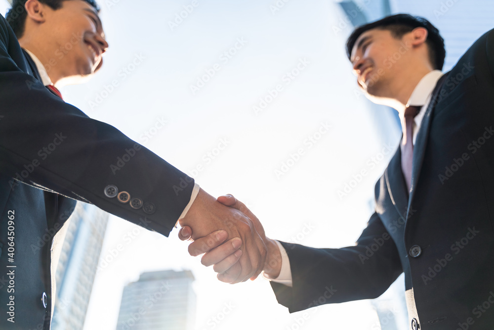 商业人士在摩天大楼背景的城市握手。